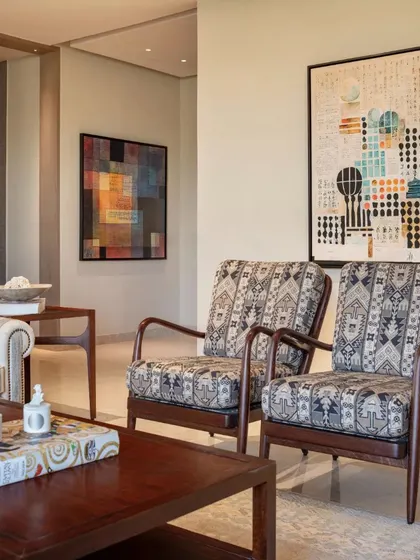 The living area of the Max128 apartment, highlighting the blend of contemporary furniture and Indian-inspired textiles.