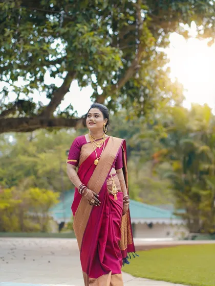 A full-length shot of the bride walking through a park. This photo captures the grace of her movement and the beauty of her traditional paithani saree in a natural setting.