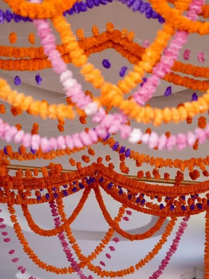 A beautiful entrance detail, with garlands of fresh orange, pink, and purple flowers creating a curtain of color for guests to walk through.