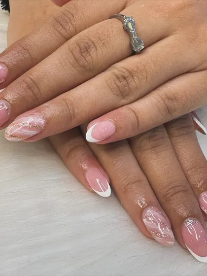 A modern twist on a timeless classic. This look combines a clean French manicure with delicate marble art and a hint of gold glitter for an elegant and sophisticated finish.