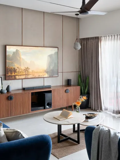 The final living room, where a textured wallpaper and wood-paneled TV unit create a sophisticated and warm focal point.