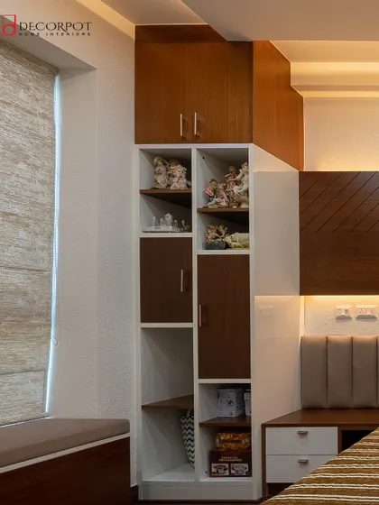 A bedroom that cleverly integrates storage with a unique stepped-design shelving unit beside the bed. The combination of open and closed storage is perfect for both display and organization.