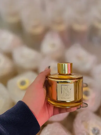 A personalized reed diffuser created for the same baby shower, matching the candle's elegant gold and custom label design.