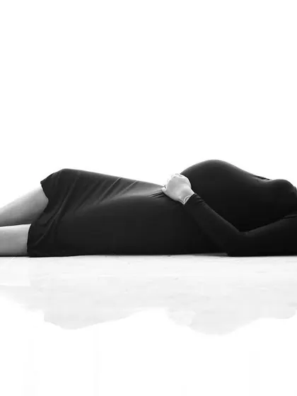 A creative black and white shot with a unique perspective. This artistic composition offers a different way to capture the beauty of the pregnant form.