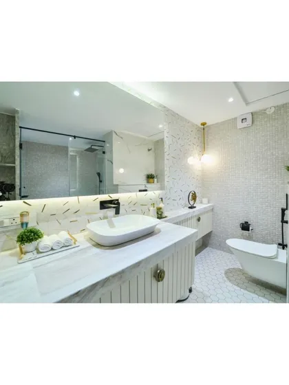 A serene and luxurious bathroom design featuring a floating vanity with a textured finish, a backlit mirror, and elegant white and gold fixtures for a spa-like feel.