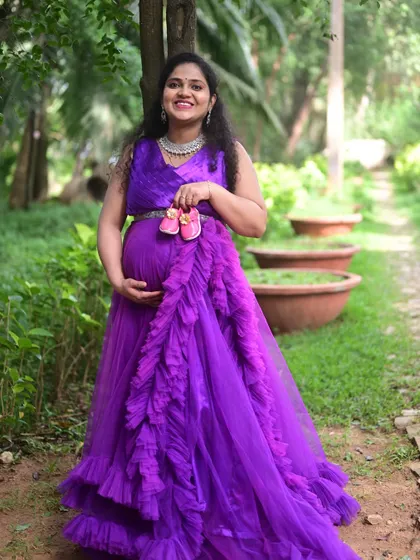 A joyful outdoor maternity shoot featuring our purple ruffle gown. We help you choose the perfect dress for your location and theme.
