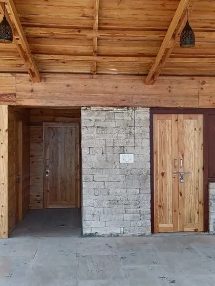 **Angling Centre, Pancheshwar:** The interior spaces are finished with wood and stone, maintaining a rustic and tactile feel. The design provides functional spaces for the angling centre while staying true to the spirit of the place.