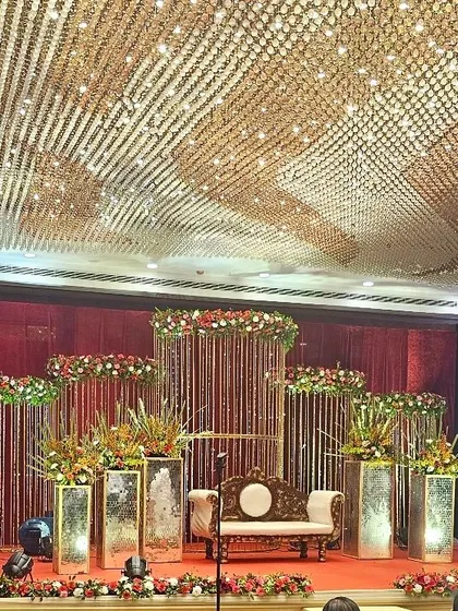 A truly magnificent stage design featuring a ceiling covered in crystal strings that catch the light beautifully. The stage itself is adorned with floral arrangements on mirrored pedestals, creating a look of pure luxury and drama.