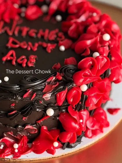 A close-up of the fiery red buttercream details on the "Witches Don't Age" cake.