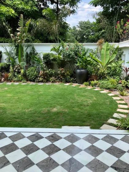 This is how the Gurugram villa garden looked in 2018, right after we finished the project. The clean lawn, checkered patio, and newly planted foliage show the foundation of what would become a lush, tropical space.