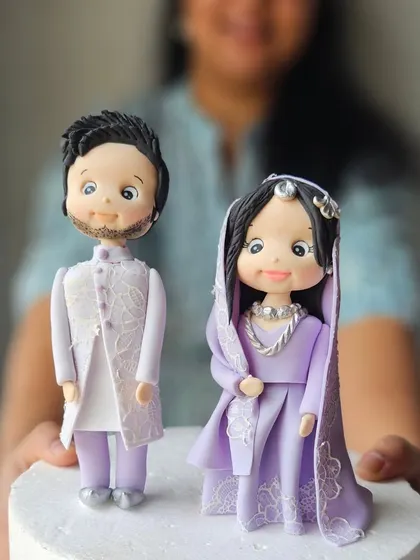 We are ready for all your wedding, reception, and anniversary cakes. A close-up of my detailed, handcrafted bride and groom figurines in traditional Indian attire.