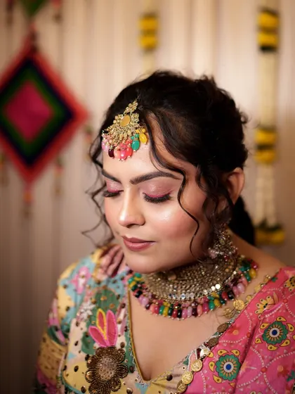A close-up of the signature Haldi makeup. The bright pink winged eyeliner adds a playful pop of color that is perfect for the festive atmosphere.