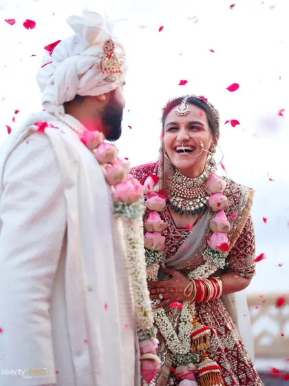 A shower of rose petals and a burst of laughter. A candid, joyful moment from the varmala ceremony in Udaipur.