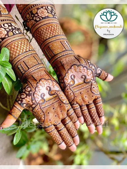 This engagement bridal design features elegant peacocks on the palms, surrounded by delicate floral and net patterns.