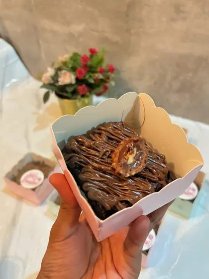 A single serving of my signature eggless brownie, drizzled with Nutella and topped with a piece of Ferrero Rocher.