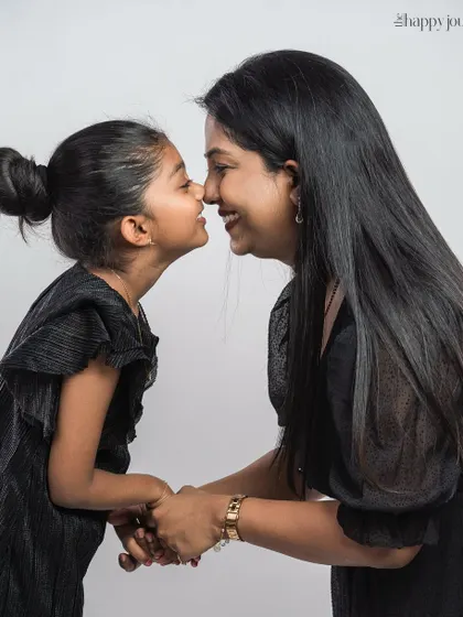 An adorable nose-to-nose moment between a mother and daughter. This playful and loving interaction is what family photos are all about.