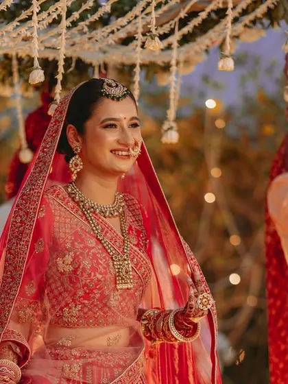 The bride's radiant smile as she walks towards the mandap, her happiness lighting up the frame.