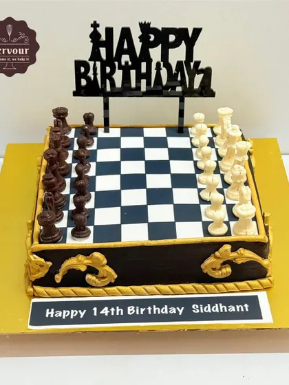 Another view of the detailed chess cake, showing the chocolate pieces and ornate gold details on the side.