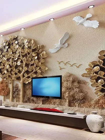 This luxurious 3D wallpaper features a golden tree and flying birds with a sculptural effect. It creates a stunning, high-end focal point behind a media console in a living room.