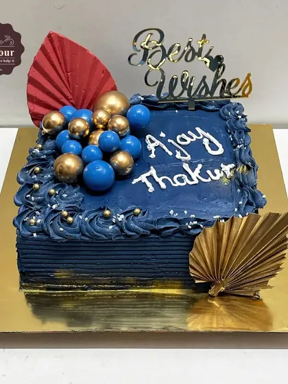 A cake designed for a retirement party. The deep blue frosting and elegant gold accents create a sophisticated look to honor a long and successful career.