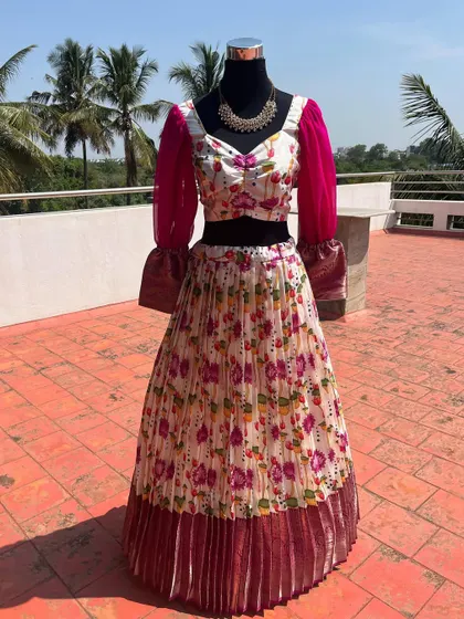 A floral print lehenga with a pleated skirt and contrasting pink puff sleeves.