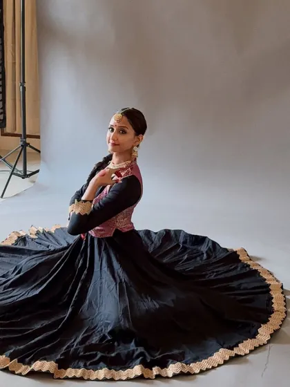 A quiet moment captured in full Kathak costume. The traditional attire, with its wide skirt, is an integral part of the dance, creating beautiful shapes during spins and movements.