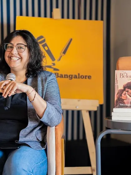 Author Shuchi Batra smiling warmly at the audience, comfortable and confident on the stage we've set for her.