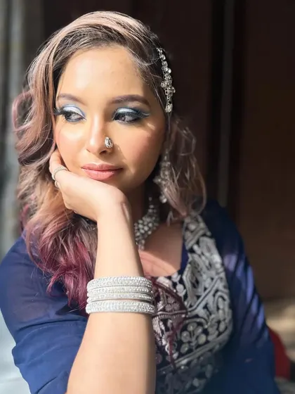 A thoughtful pose of a model with a full cut-crease eye look, perfect for a Walima bride. The silver eyeshadow and cool-toned jewelry create a sophisticated and icy-glam aesthetic.