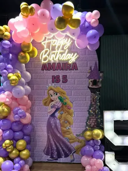 A magical Rapunzel princess theme for Amaira's 5th birthday, with a purple and pink balloon arch and a light-up number '5'.