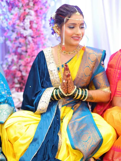 A moment of prayer during the ceremony. Her hands, adorned with mehndi and green bangles, are a beautiful part of the Maharashtrian bridal tradition.