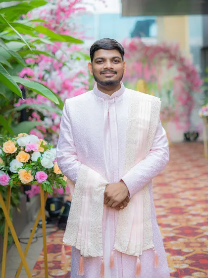 A classic portrait of the groom on his Haldi day, smiling in his elegant pastel sherwani.