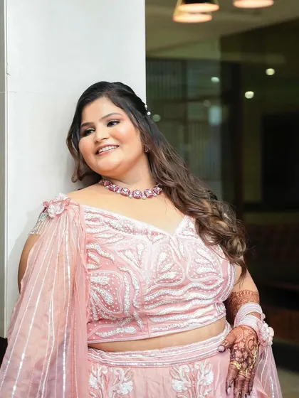 A happy, smiling close-up of the bride, her soft makeup and loose curls creating a romantic engagement look.