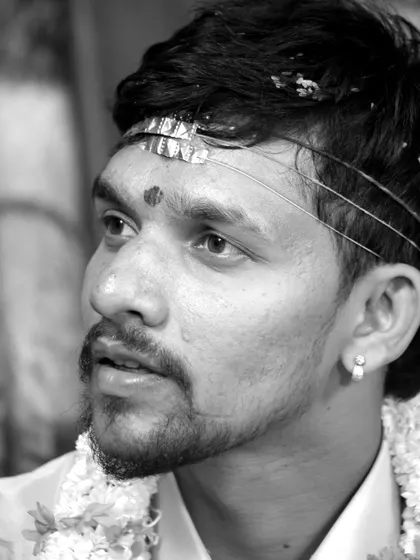 A candid black and white portrait of a groom, capturing his emotions during the wedding ceremony.