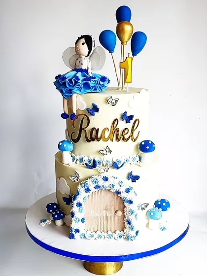 Another view of the two-tier fairy cake, highlighting the handcrafted door and mushroom details.