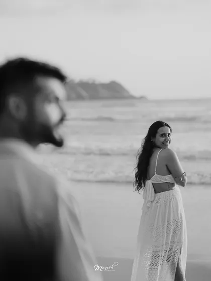 A beautiful black and white portrait from a Goa pre-wedding shoot, capturing a candid glance on the beach.