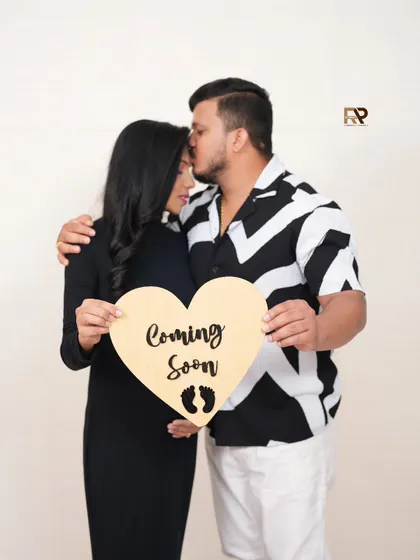 Coming Soon! This couple's portrait uses a heart-shaped wooden sign to announce their pregnancy. It's a simple, rustic, and beautiful way to share your news.
