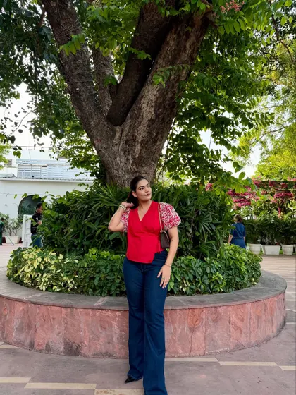 A casual yet put-together look with a red top featuring printed puff sleeves, paired with dark wash flared jeans.