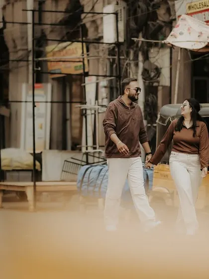 Finding romance in the everyday. This couple walks hand-in-hand through a bustling city street, creating a cool, urban vibe for their pre-wedding shoot.