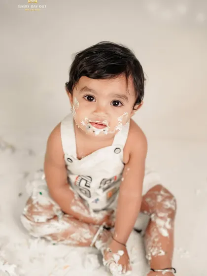 A happy baby covered in cake after a fun smash session. These messy moments make for the most memorable photos.