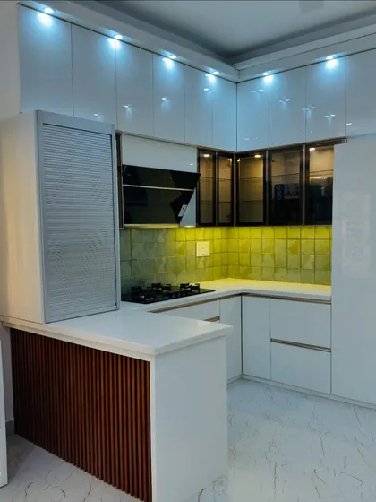 Another angle of the transformed kitchen, showing the breakfast counter with a wooden fluted panel and a rolling shutter for appliances.