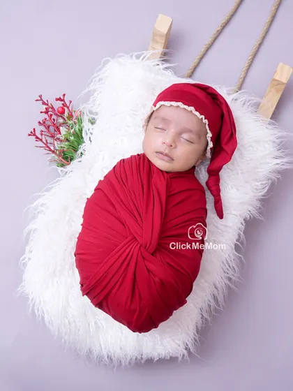Another angle of our festive Christmas setup, showing the baby peacefully sleeping in a deep red swaddle, ready for their first holiday celebration.