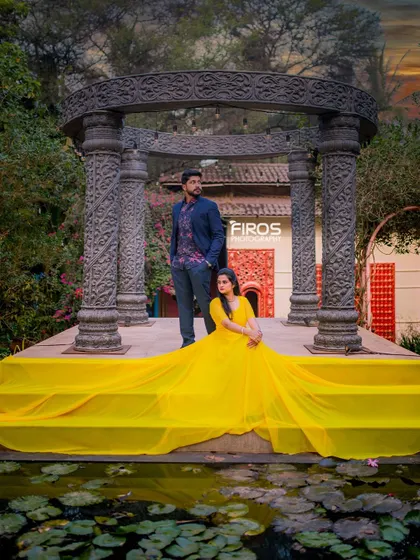 A duplicate of the yellow gown shot, showcasing its brilliant color against the stone backdrop. This pose is perfect for a grand and memorable pre-wedding photo.