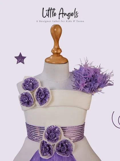 A little splash of purple. A close up on a mannequin showing the floral and feather details of a custom dress.