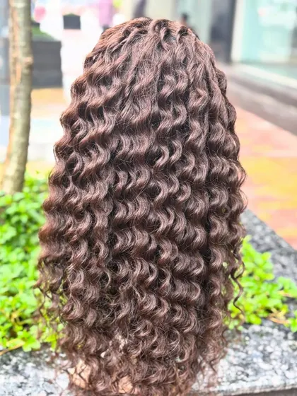 The back of the dark brown curly wig, full of beautiful, defined curls.