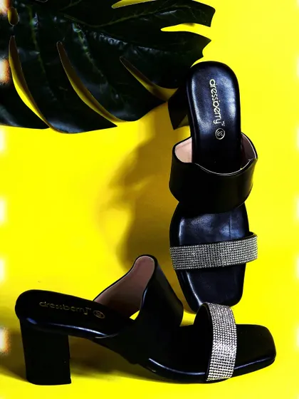 A creative composition of the Dressberry heels, using interesting angles and a large leaf prop to create a stylish and modern fashion photograph.