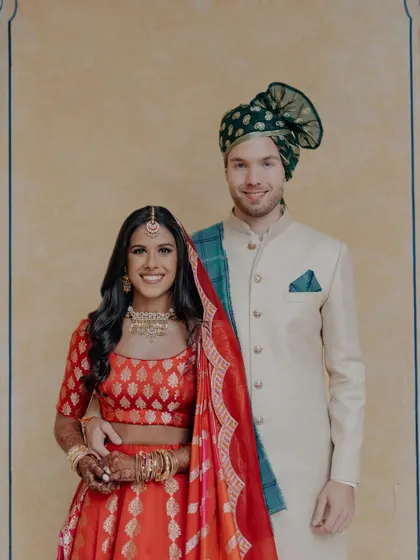A classic portrait of the cross-cultural couple, Avni and Matt, in their stunning wedding attire. This image showcases the beautiful blend of Indian and Western traditions.