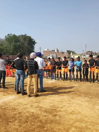 A coach addressing a group of young players during the trials. Clear instruction and encouragement are vital, even in a competitive selection environment.