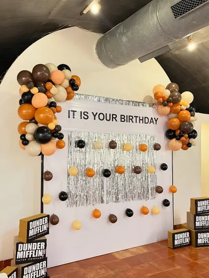 The 'Dunder Mifflin' party entrance featured a welcome sign from the "party planning committee" and stacks of branded paper boxes, setting the tone for 'The Office' theme.