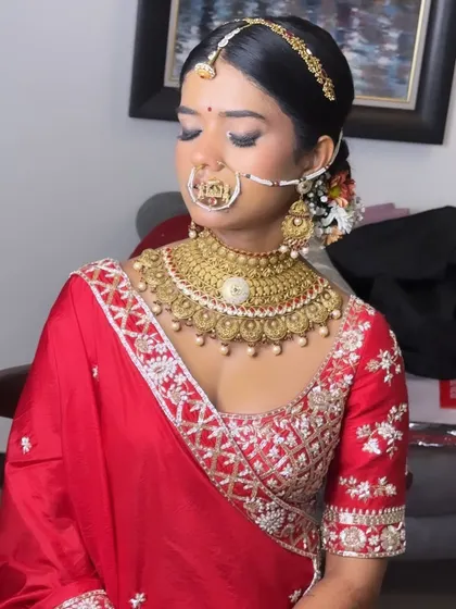 Another angle of Anushree's regal bridal look. The makeup was designed to be bold yet elegant, ensuring her features were beautifully highlighted beneath the traditional bridal jewelry.