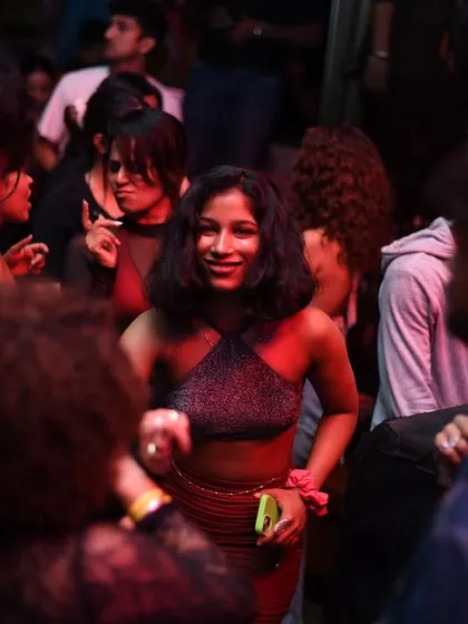 A candid shot of a girl dancing, lit by the red glow of the club.